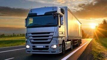 lorry-driving-on-rural-road-at-sunset